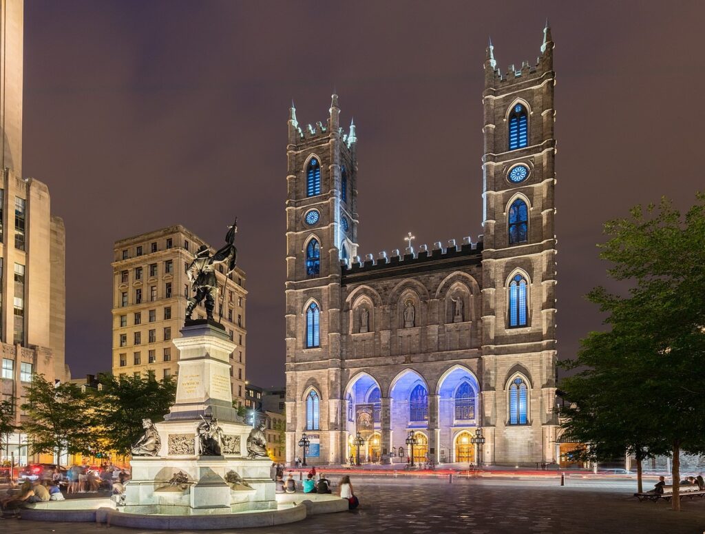 Notre Dame Basilica in Montreal lit up with blue lighting at night; By Diego Delso