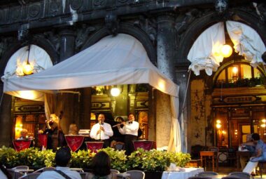 Enchanting night view of Cafee Florian patrons listening to a live music conercert in the in St. Mark's Square, Venice