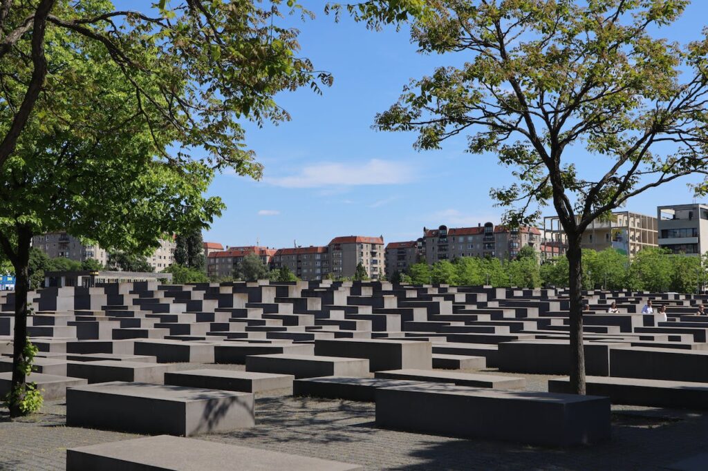A view of the Holocaust Memorial in Berlin with city buildings in background